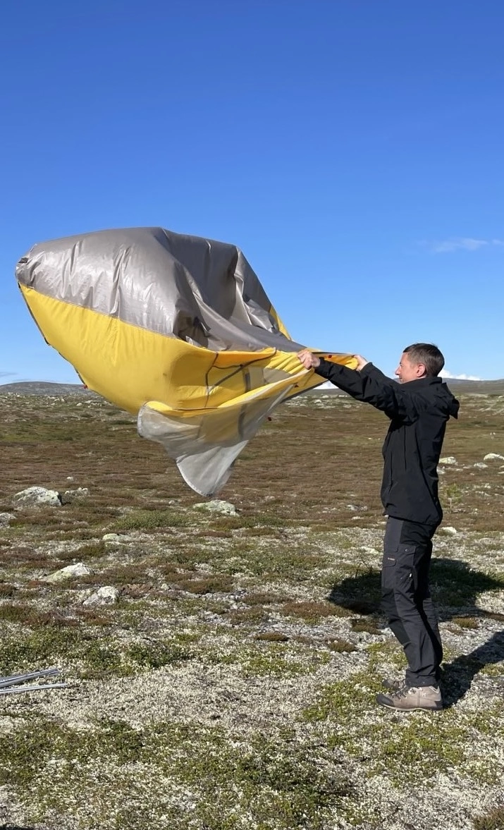 Karl holding a tent which is blowing in the wind.